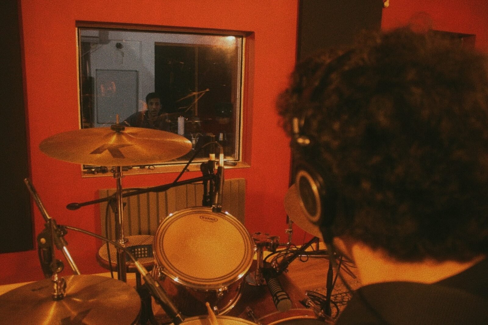 Baterista grabando, vista desde la sala de control
